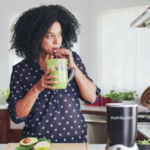 Modelo disfrutando de un smoothie con la Nutribullet® RX en color negro, escena lifestyle en una cocina