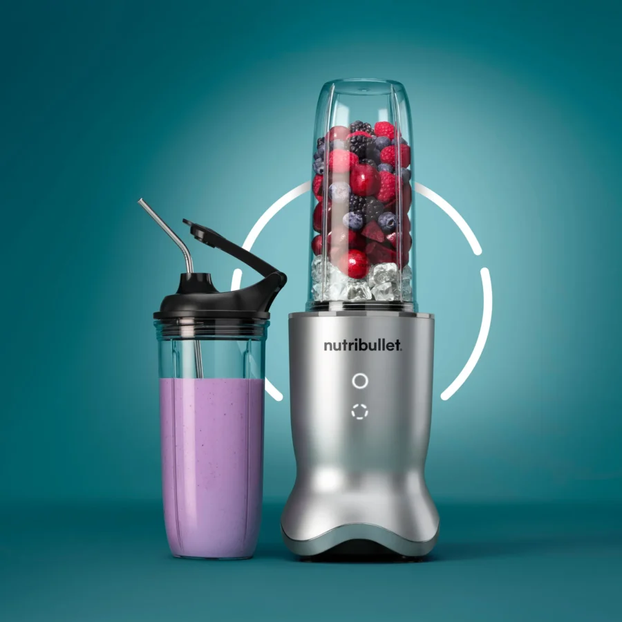 nutribullet® Ultra en color Silver de frente con vaso adicional y tapa To-Go, mostrando el uso sobre fondo verde aqua oscuro con un anillo de luz en el centro