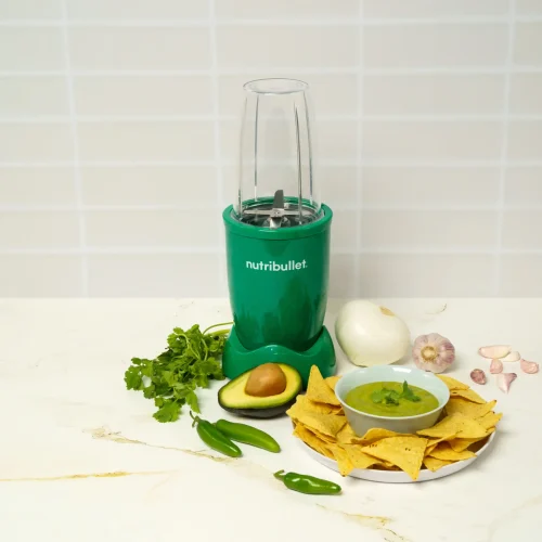 Salsa Verde, una nutribullet® 600W Esmeralda de la Colección Glossy, ingredientes en la mesa y un tazón lleno de salsa