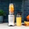 nutribullet® Ultra en color silver en la cocina con una combinación de frutas y nueces en el vaso y un vaso adicional con smoothie