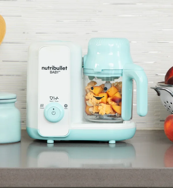 nutribullet® Baby Steam & Blend en una encimera de cocina con una combinación de verduras y frutas en el interior del tazón listas para mezclar
