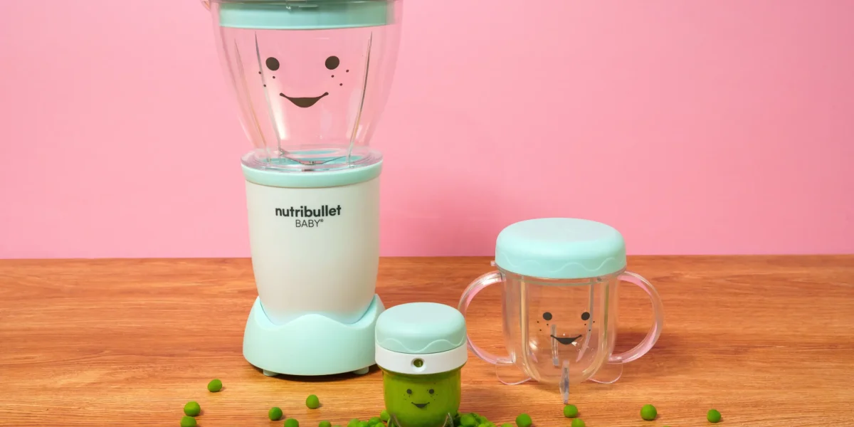 nutribullet® Baby con sus accesorios sobre una mesa, con el contenedor de guardado lleno de puré de chícharo