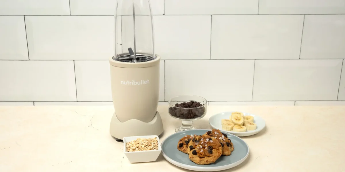 Galleta de Avena, una nutribullet® 900W Arena Mate de la Colección Mineral, junto con ingredientes de la receta y un plato con varias galletas